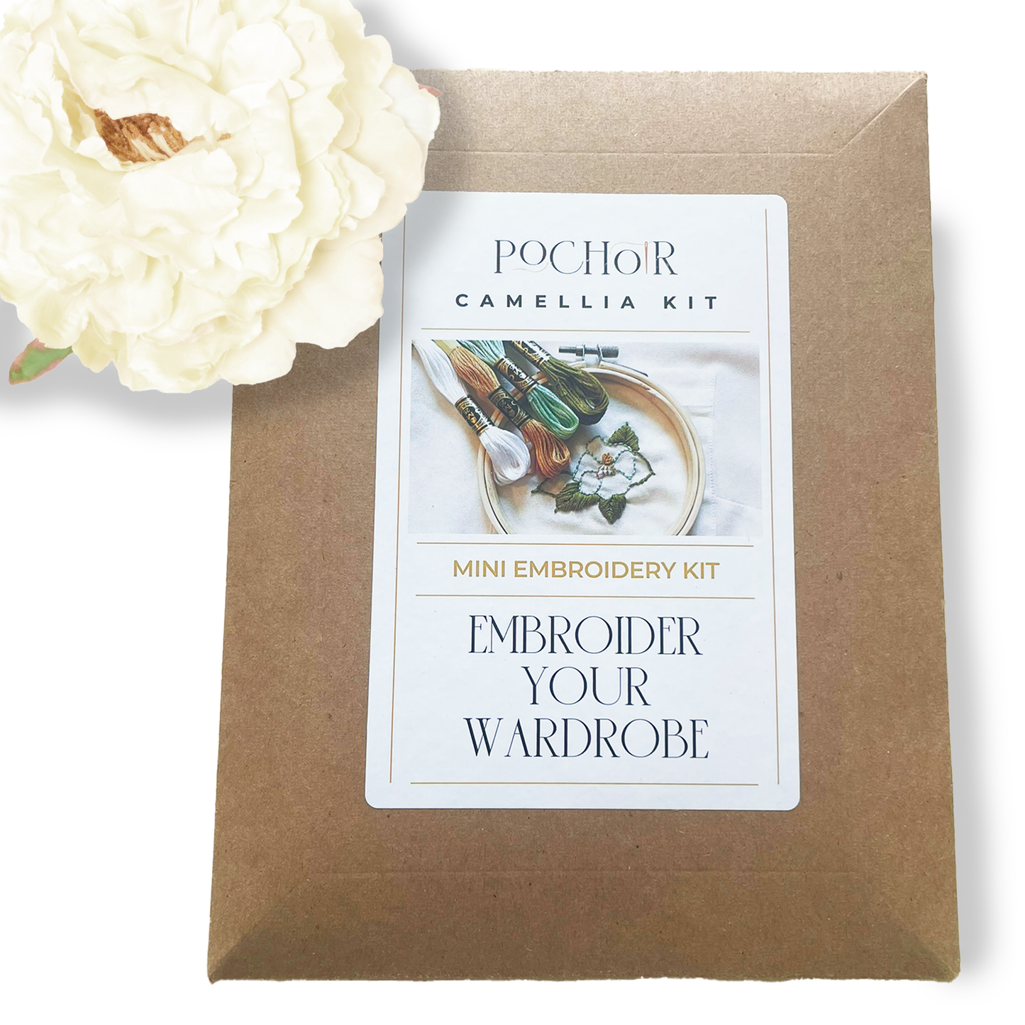 PochoirNYC Camellia Mini Kit cardboard packaging with a label on a white background. An artificial white peony is place above the kit in the left hand corner.