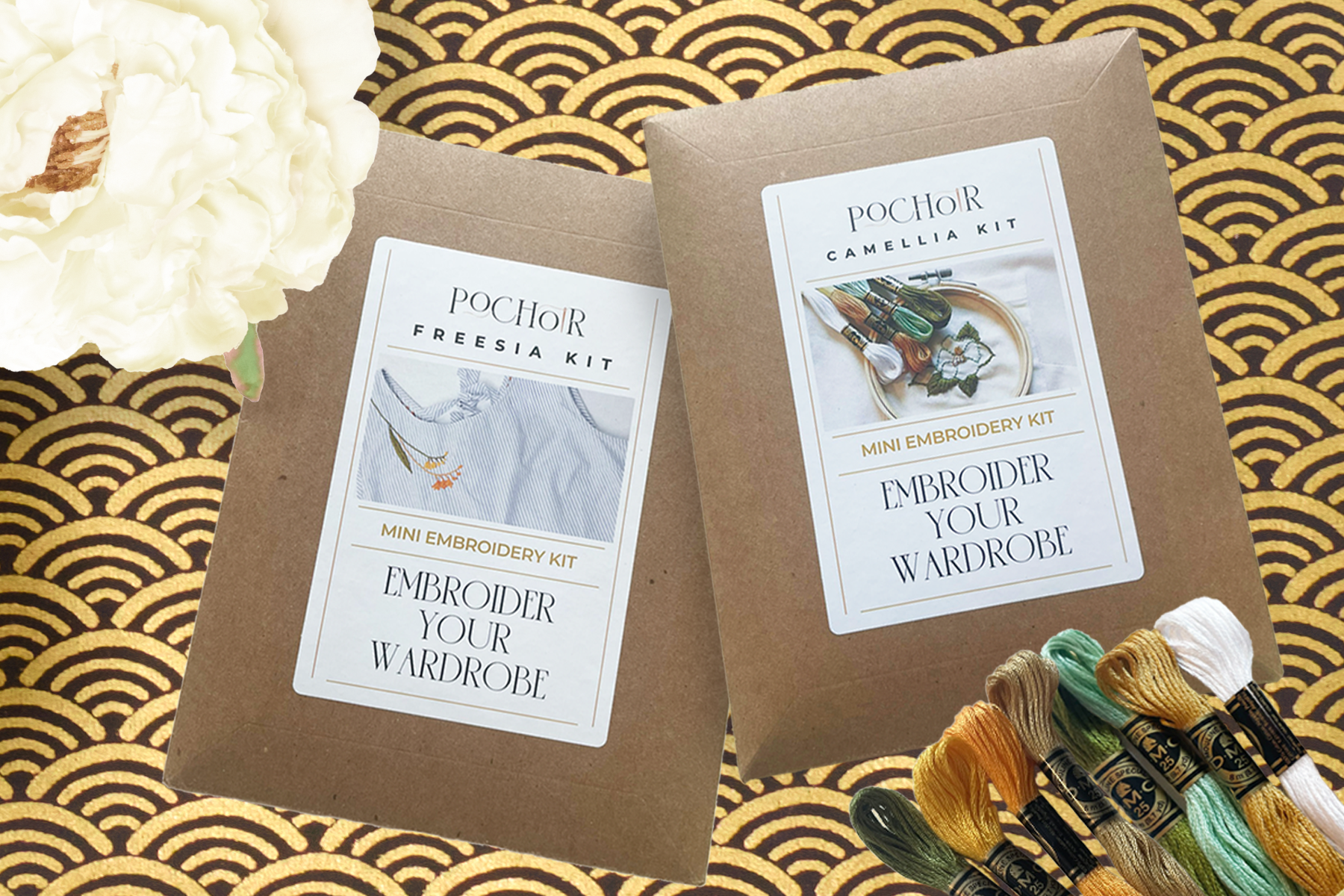 Two beginner embroidery kits with labels on brown paper envelopes against a decorative gold and black background.